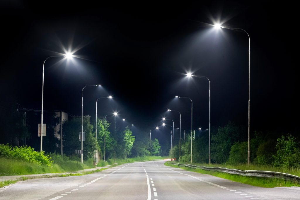 solar vs wired streetlights comparison showing roadway lighting at night